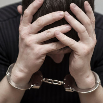 Man holding his head in his hands after learning about the consequences of a felony record.