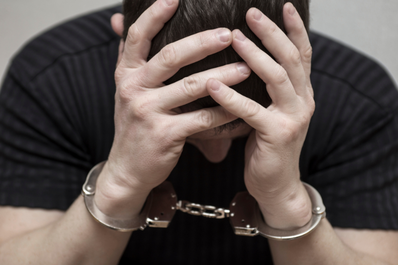 Man holding his head in his hands after learning about the consequences of a felony record.