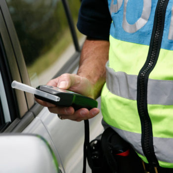 Police officer administering a breathalyzer test.