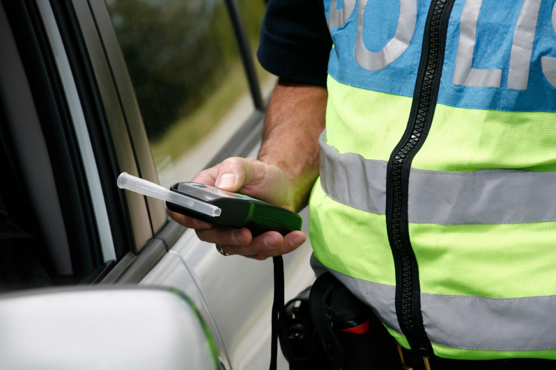 Police officer administering a breathalyzer test.