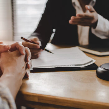 legal consultants, notary or justice lawyer discussing contract document with customer and wooden judge gavel on desk in courtroom office, business, justice law, insurance and legal service concept