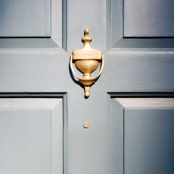 Background of vintage blue painted door and knocker vignette
